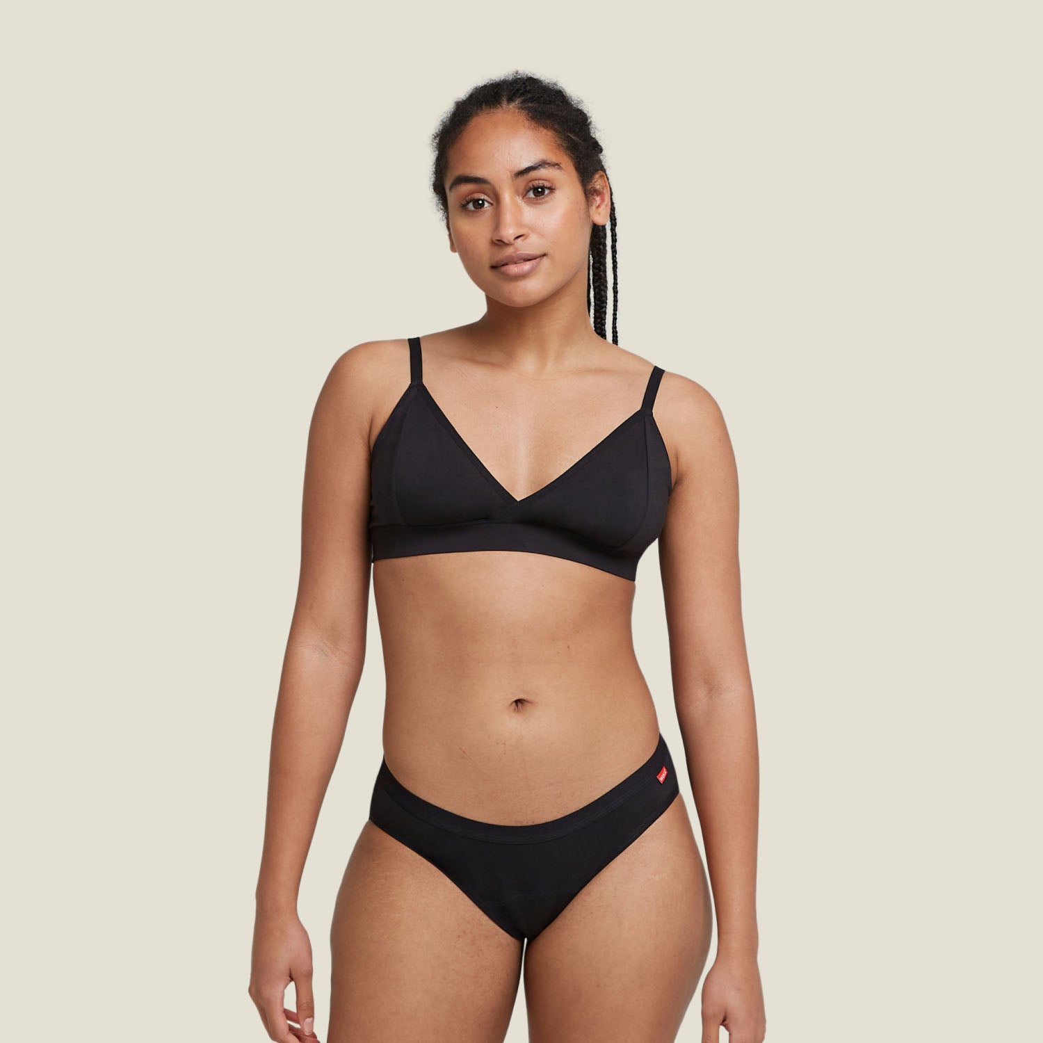 Woman wearing WUKA Basics™ Hipster Period Pants for medium flow, front view full body in black underwear set.