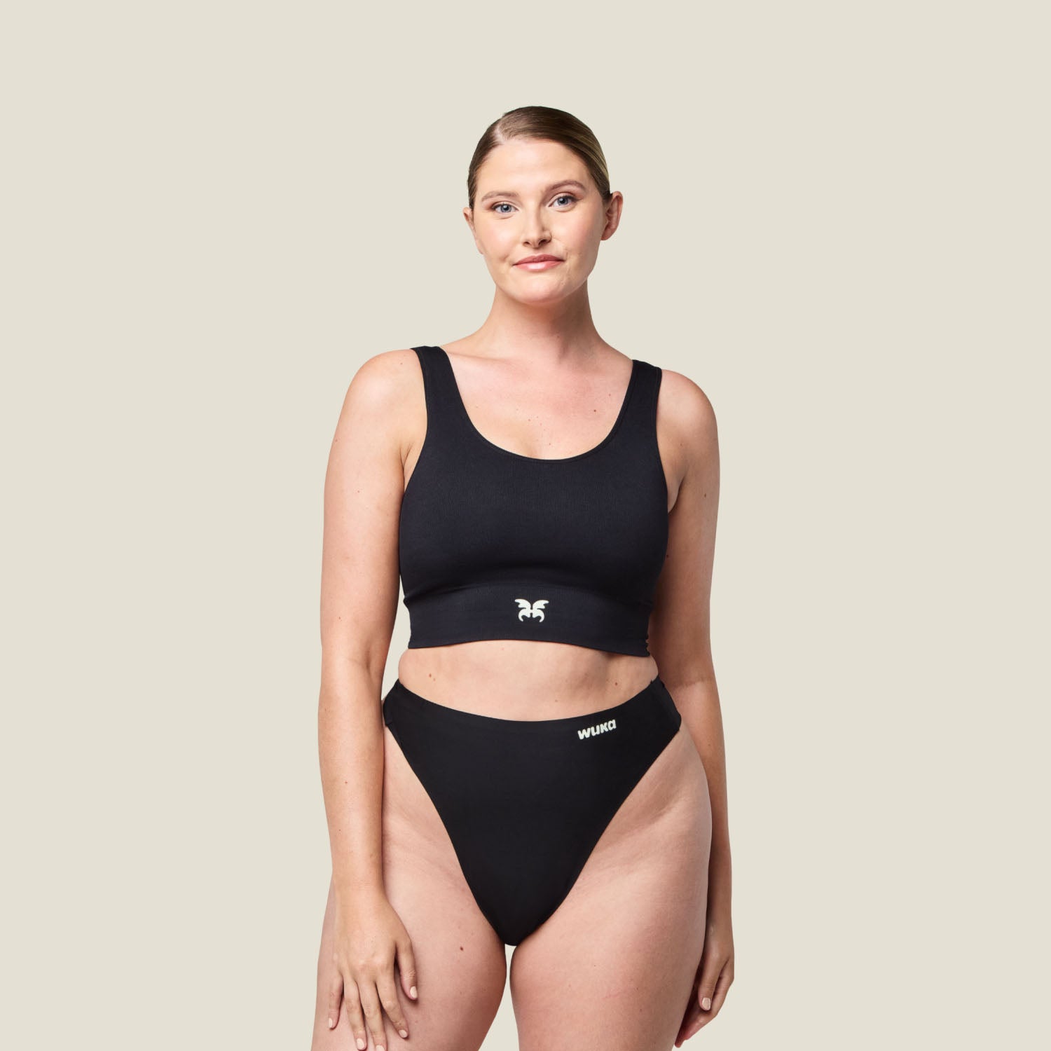 Model wearing WUKA Stretch Thong in black, designed for light flow days with sleek, seamless comfort and high-rise fit.