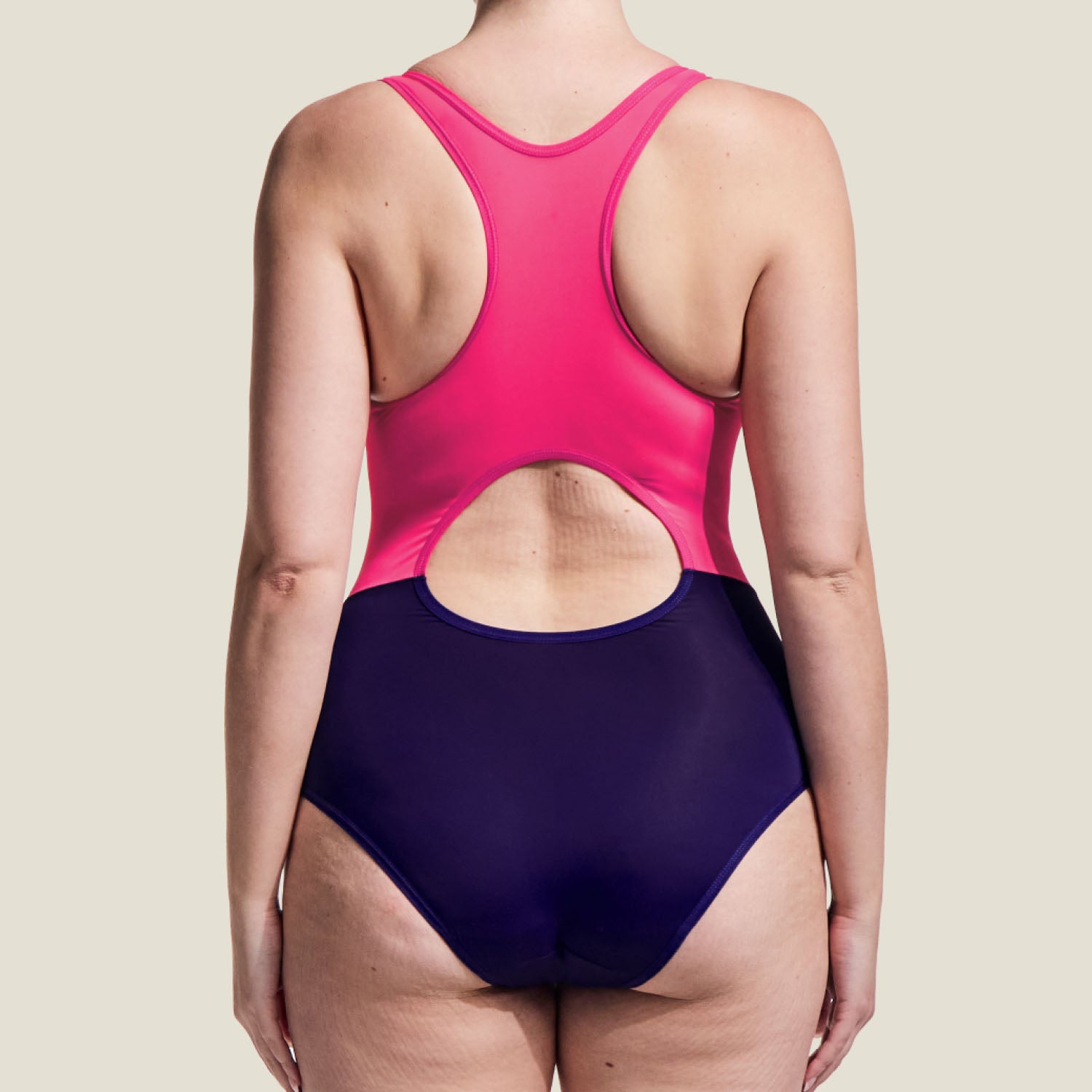 Back view of WUKA Teen Period Racerback Swimsuit in pink and purple, featuring racerback cut with keyhole detail for comfortable swim support.