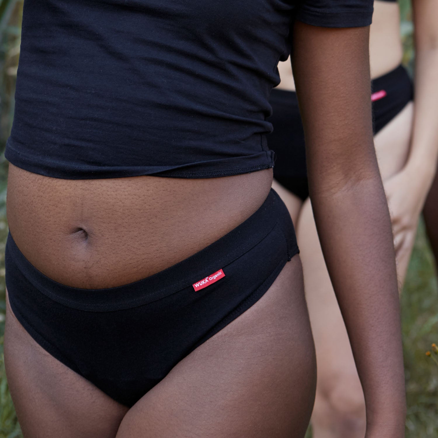 Confident model wearing WUKA Ultimate™ Bikini heavy flow period underwear outdoors – sustainable comfort and body positivity.