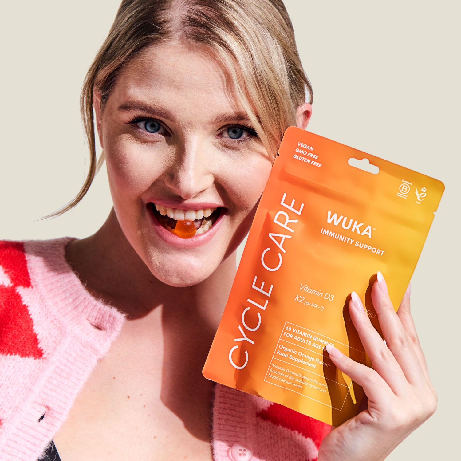 Smiling woman enjoying WUKA Immunity Support gummies for daily vitamin D3 and K2 wellness boost.