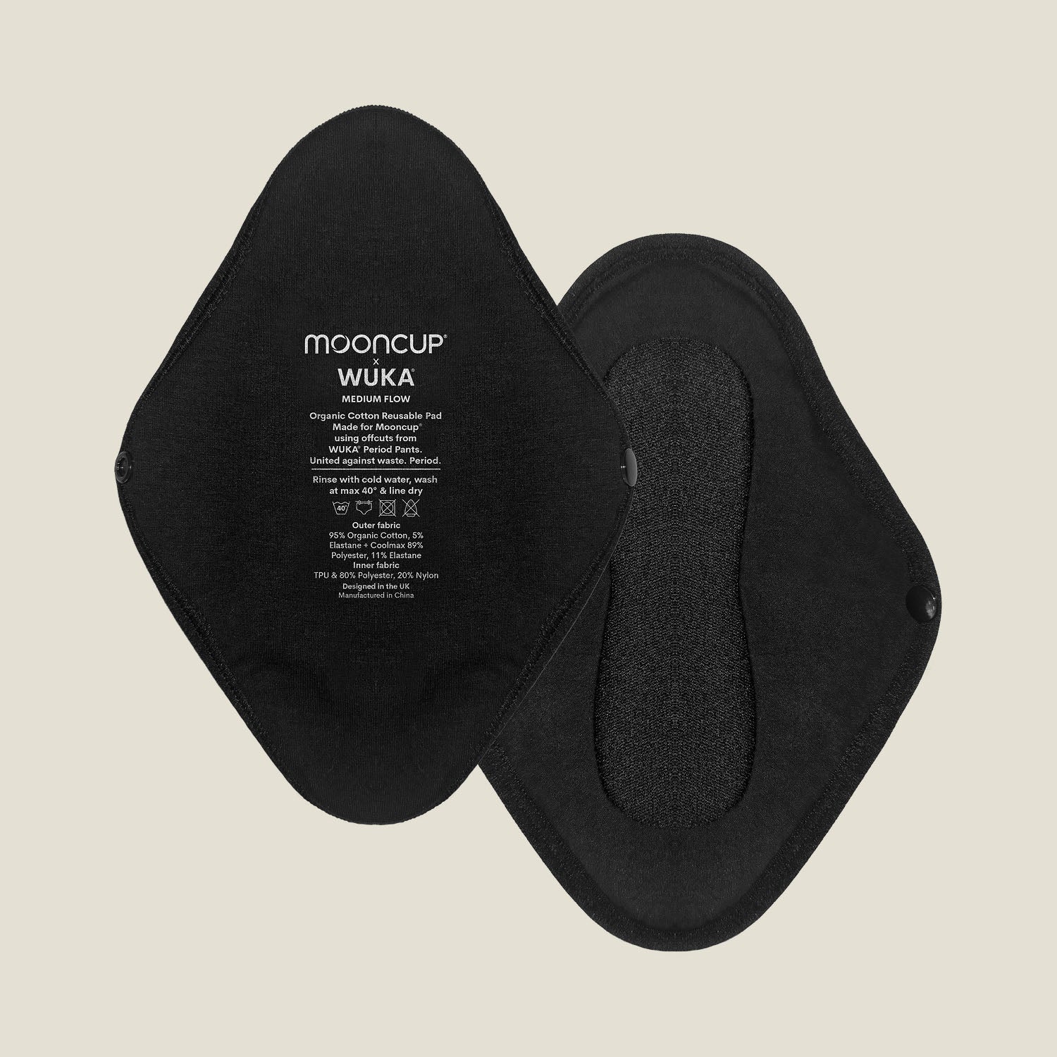 Flat lay of two black reusable period pads for medium flow, showing both front and back sides with snap closures and printed WUKA x Mooncup branding.