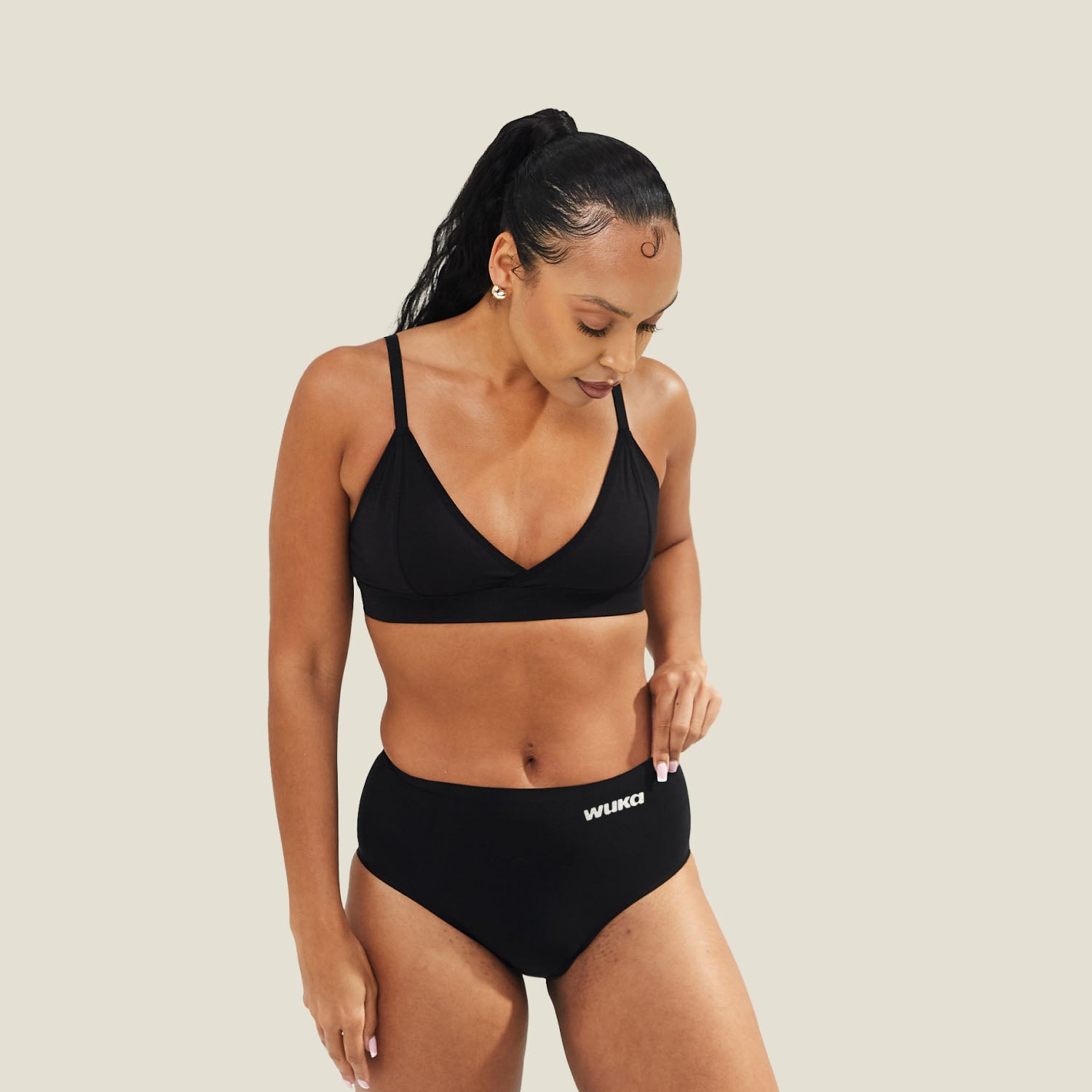 Model wearing WUKA Stretch Seamless Midi Brief in black for medium period flow – front view showing comfortable, high-waisted fit.