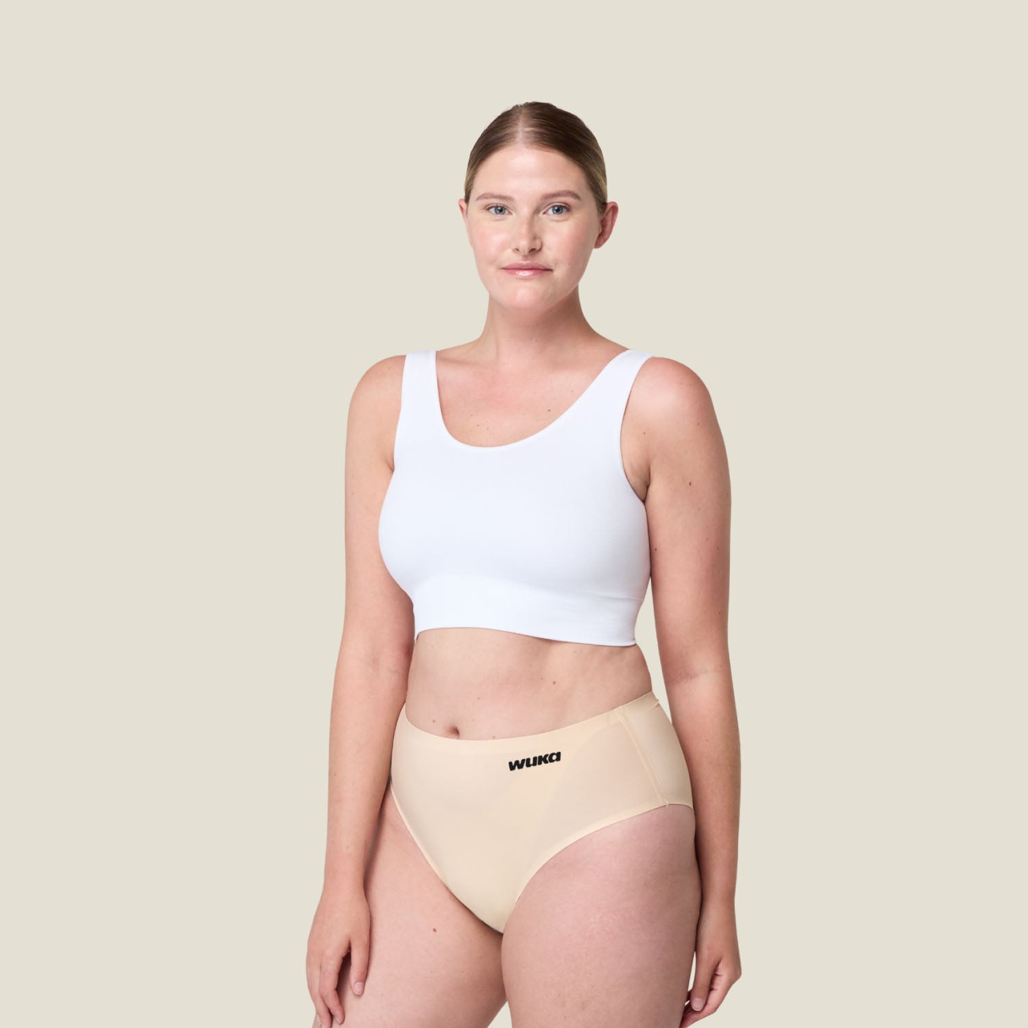 Plus-size model wearing WUKA Stretch Seamless Midi Brief in Light Nude for heavy flow, leak-proof period underwear with stretch fit, sustainable and comfortable.