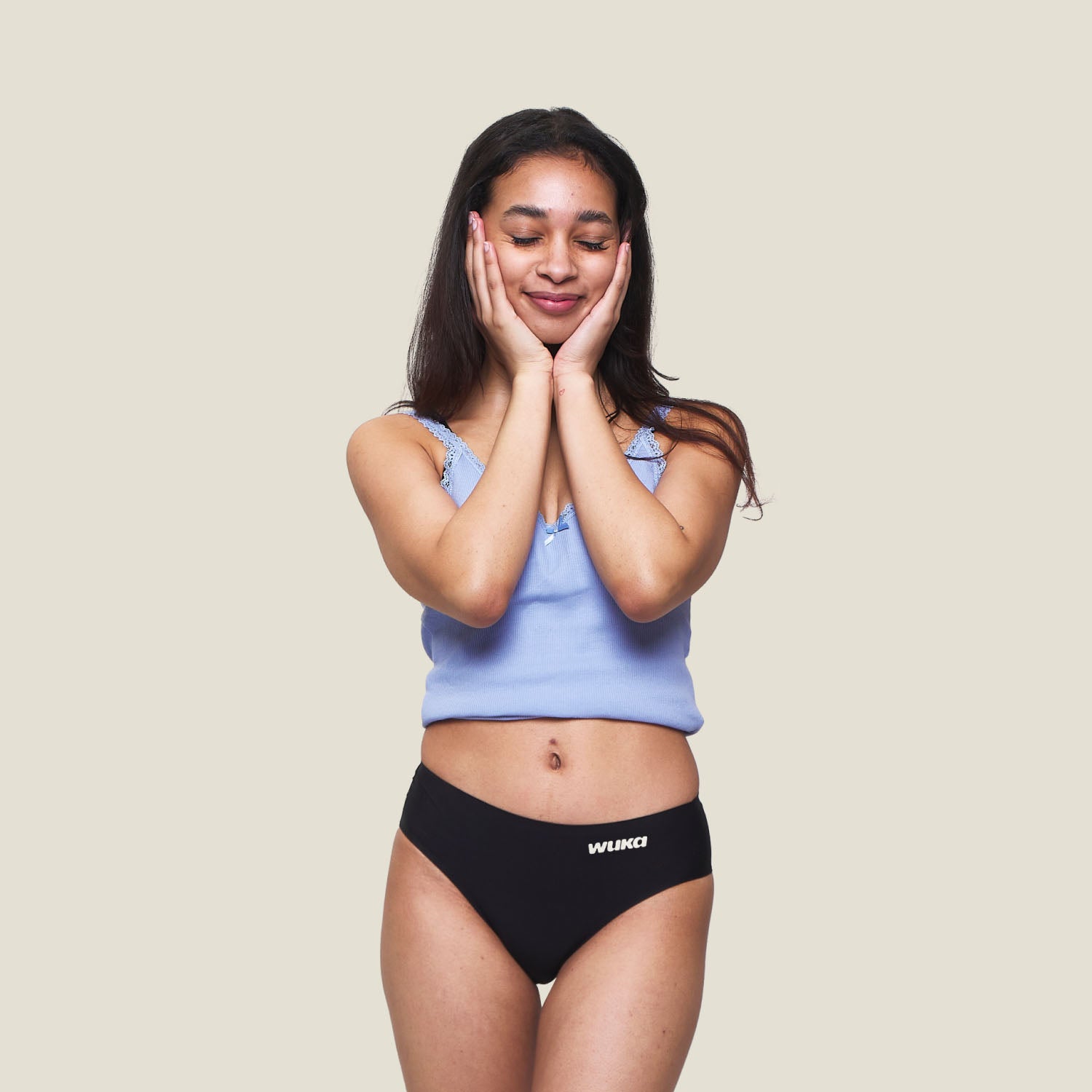 Teen girl smiling and wearing WUKA Teen Stretch Seamless Period Pants in Black for heavy flow, comfortable and discreet leak-proof underwear.