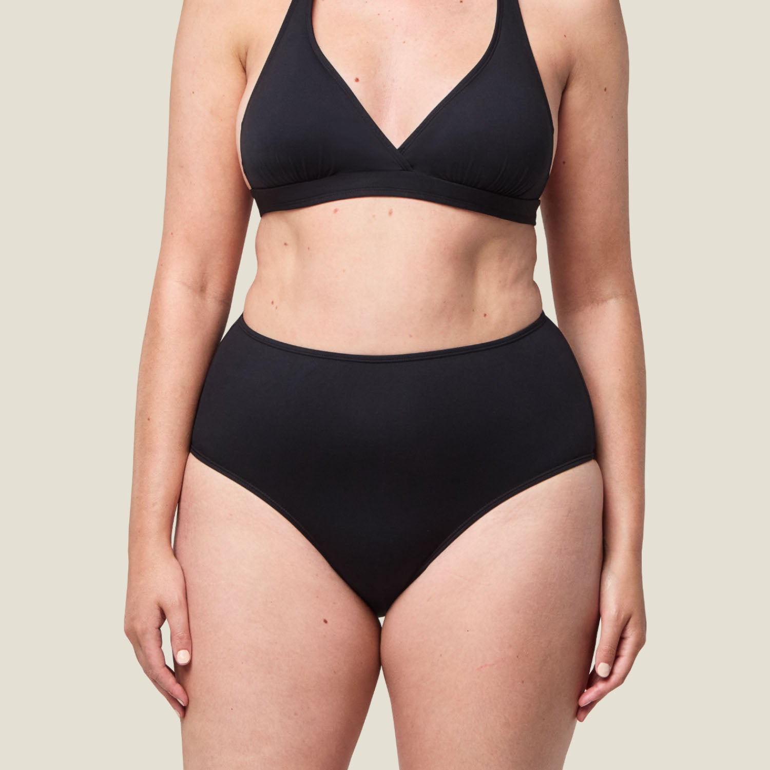 Close-up front view of WUKA Swim High Waist bikini bottoms in black, offering discreet light flow period protection for confident swimming.