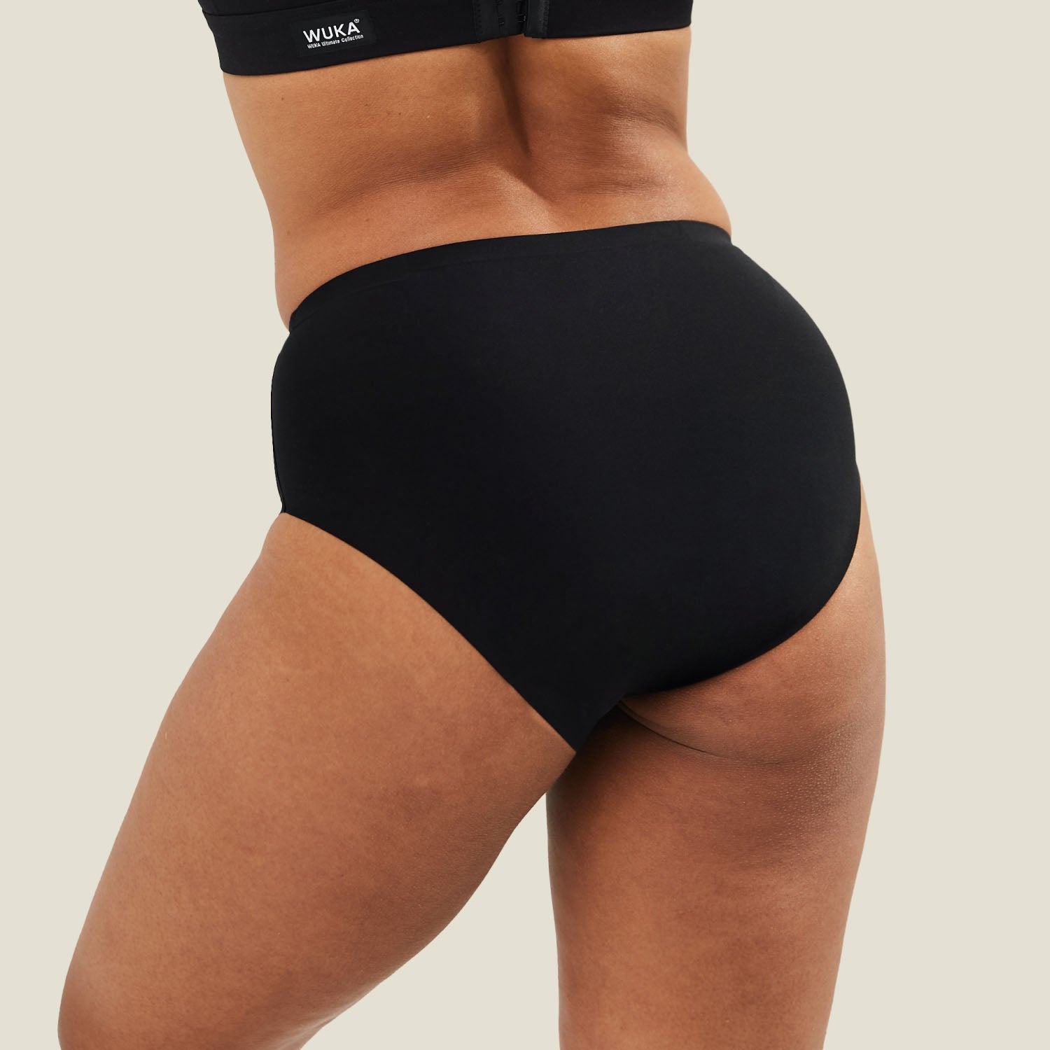 Back view of WUKA Stretch Seamless Midi Brief in black, showcasing full coverage and seamless design ideal for everyday period protection.