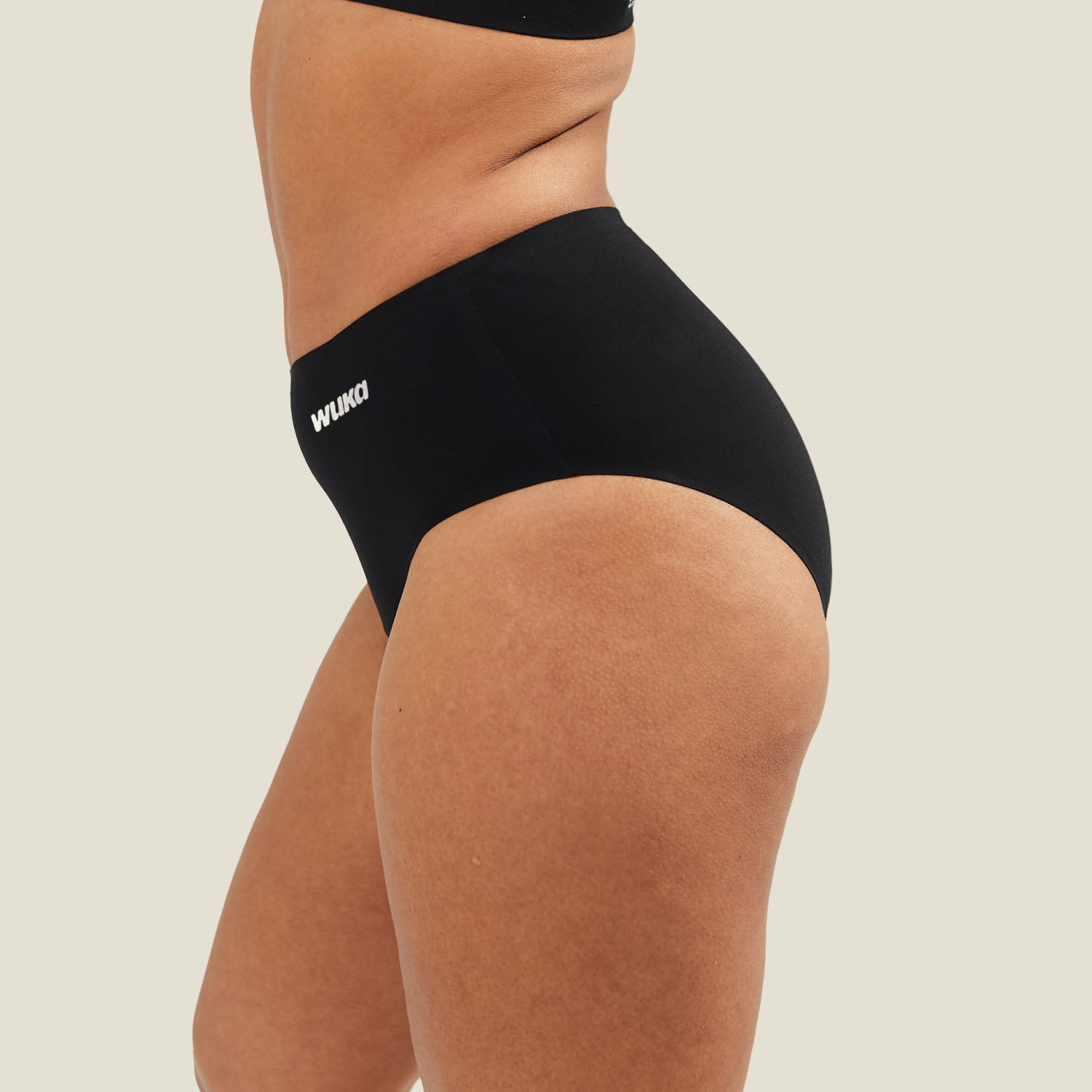 Side profile of WUKA Stretch Seamless Midi Brief in black, demonstrating contour-hugging stretch fabric and comfortable waistband.