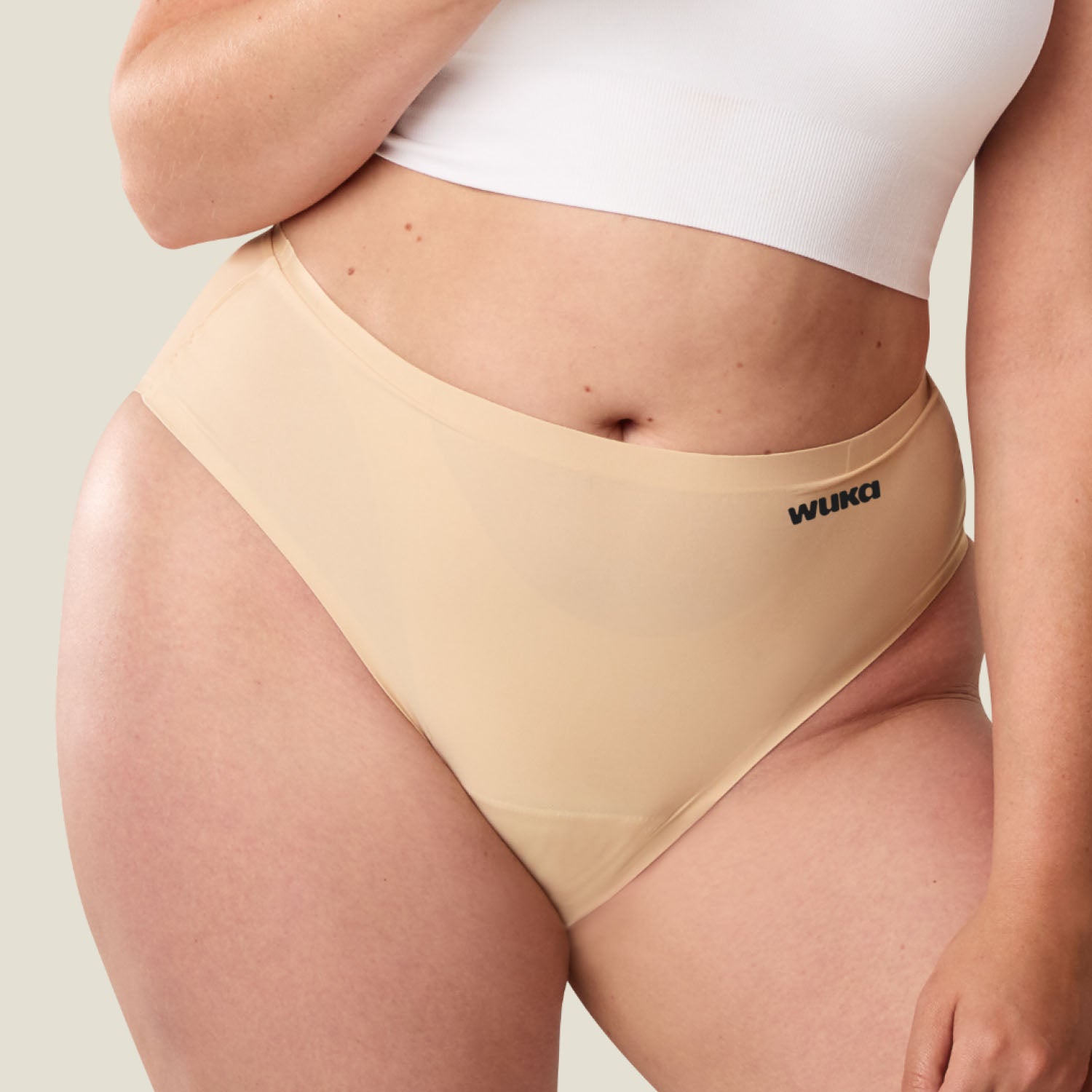 Lifestyle photo of model wearing WUKA heavy flow seamless midi brief in Light Nude, period pants offering comfort, confidence, and eco-friendly protection.